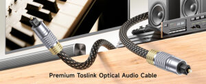 Black braided TOSLINK SPDIF optical audio cable with square optical connectors, placed with smart TV and soundbar